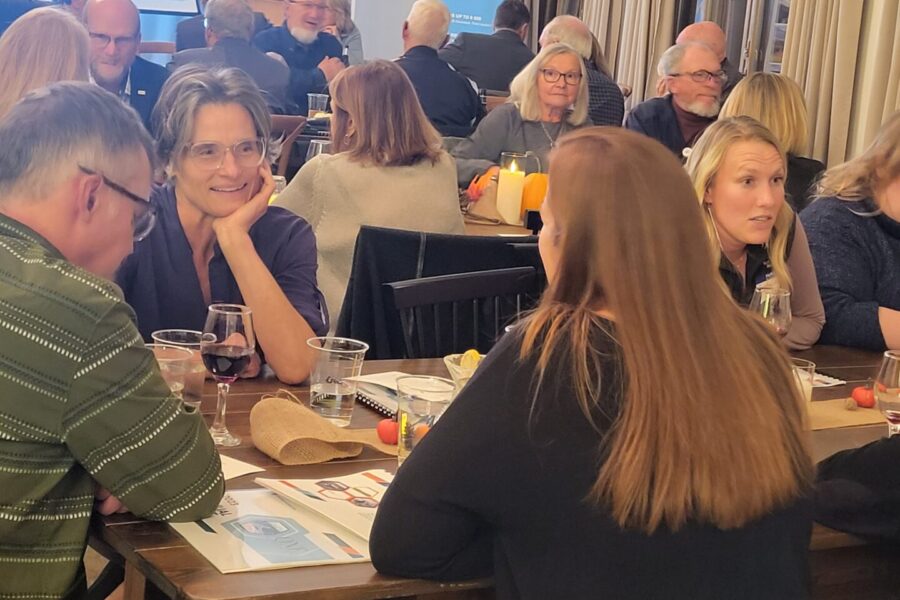 Ladies and men eating at a long table