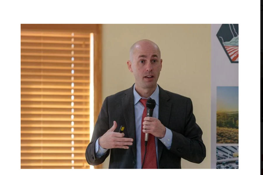 Dr. Nathan Perry, a man in a suit speaking into a microphone