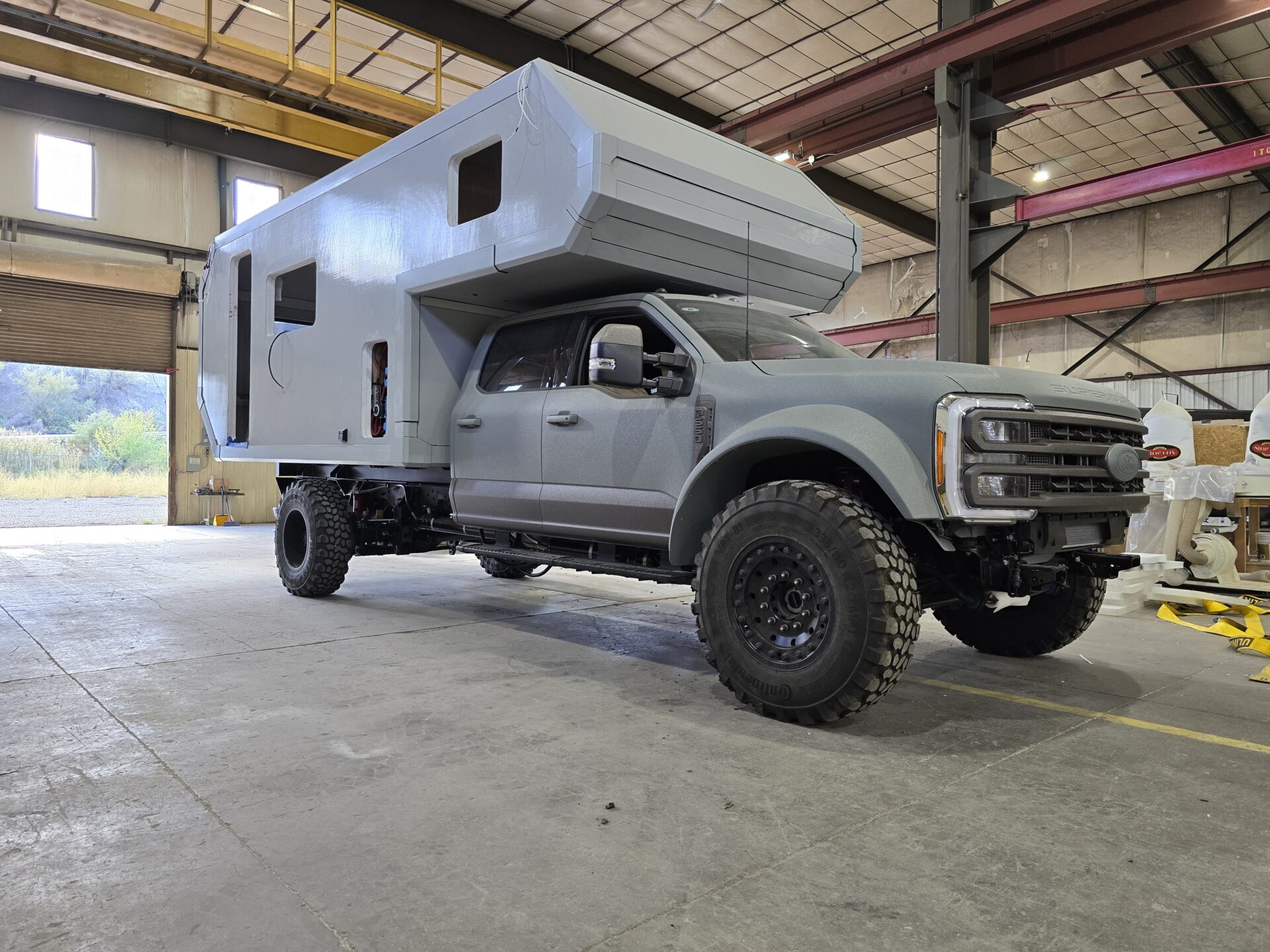 Gay pickup with gray camper in a large warehouse