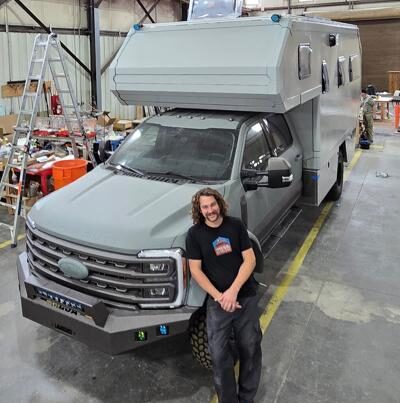 man standing in front of luxury camper