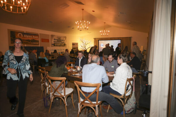 Guest Enjouing 2025 Annual Meeting at tables in a softly lit venue